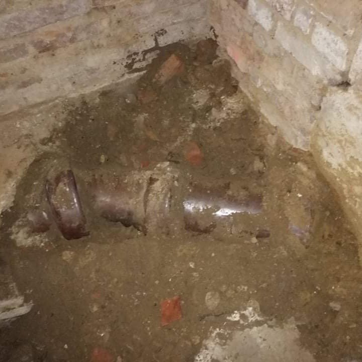Altes Kanalrohr im Kellerbereich zwischen Ziegelwänden