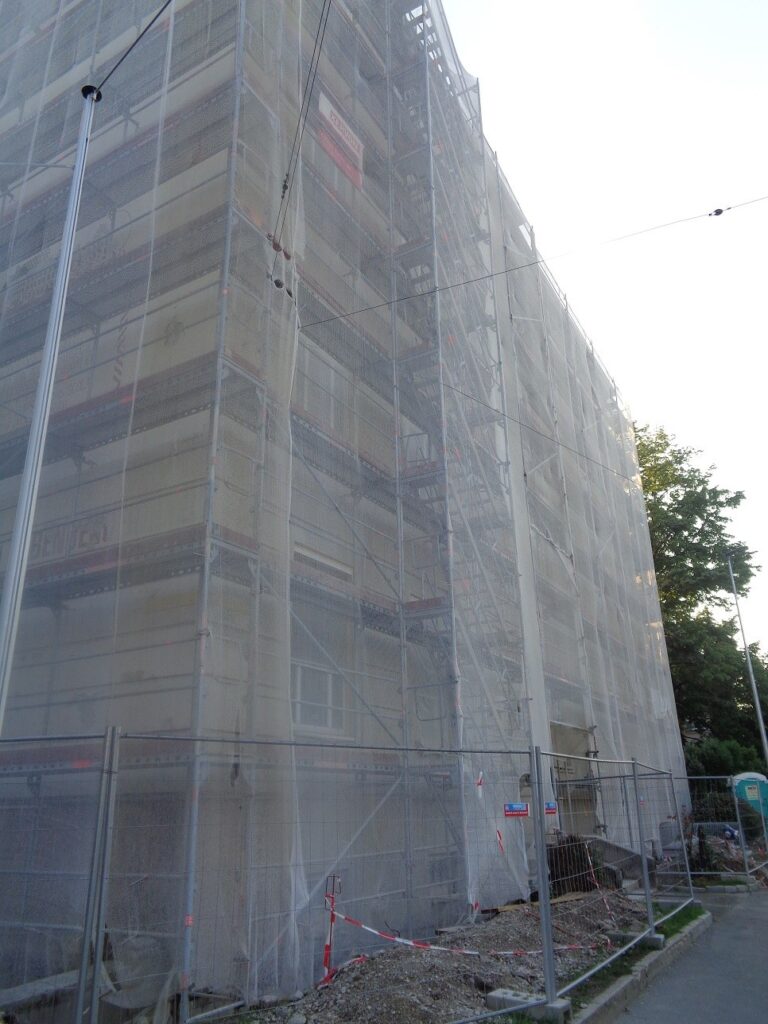 Gerüst mit Netz an der Straßenfassade einer Schule in Wiener Neustadt