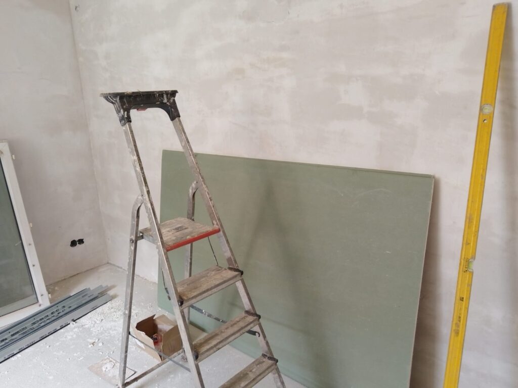 Gipskartonplatte, Leiter und gespachtelte Wand im Zimmer