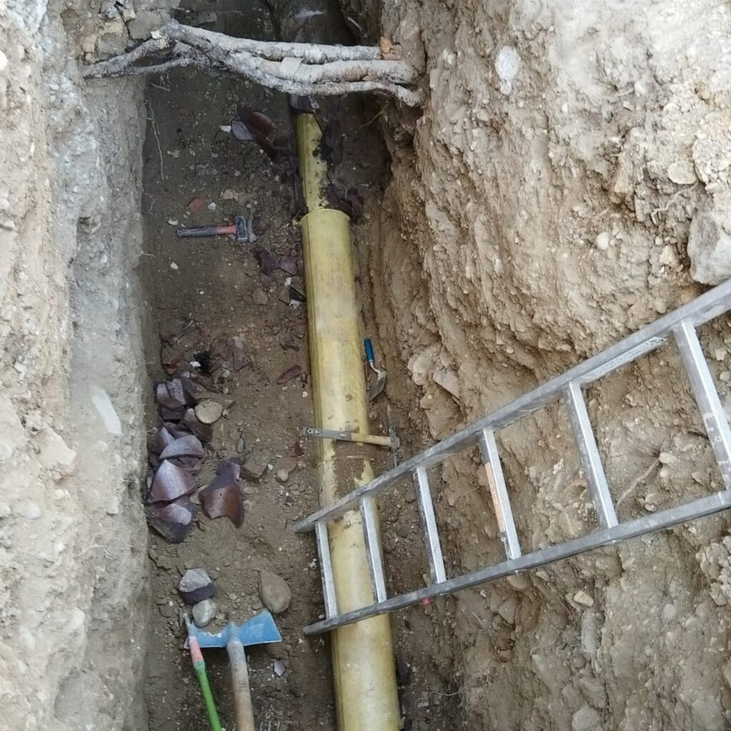 Tiefer, schmaler Graben mit Leitungen