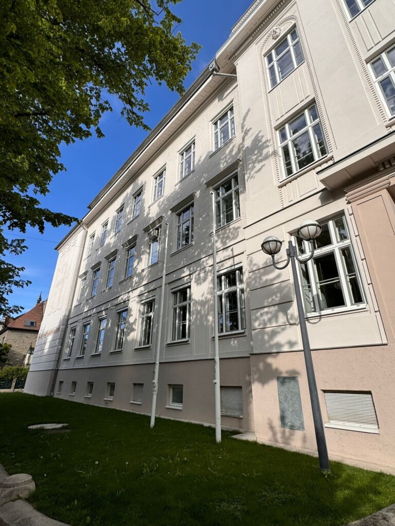 Sanierte Straßenfassade der Schule in Wiener Neustadt mit frischem Zupfputz