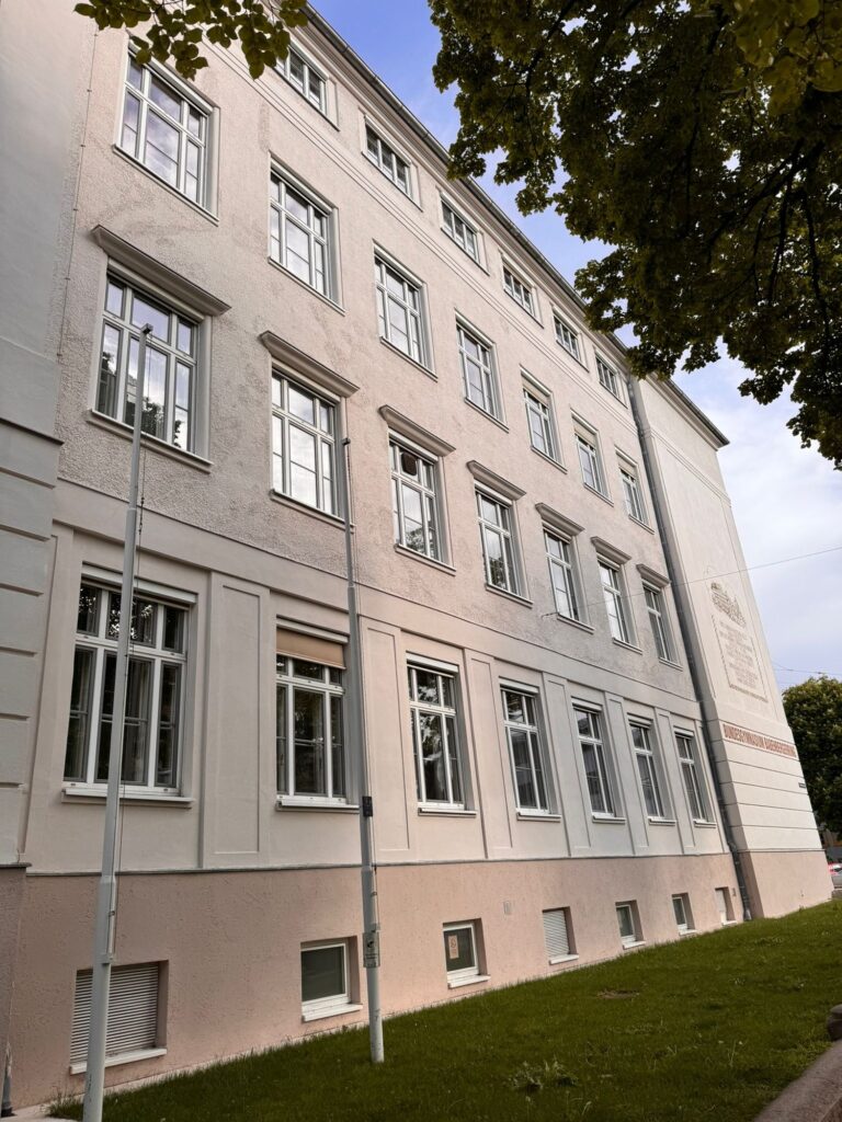Sanierter Eingangsbereich der Schule mit Portikus und Fassadenschmuck