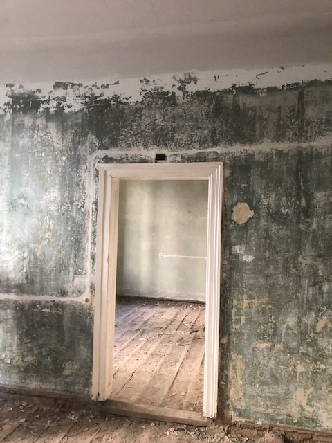 Wand mit Altschäden im Durchgang vor der Sanierung