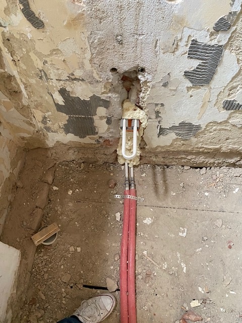 Verlegte Heizrohre am Boden und an der Wand