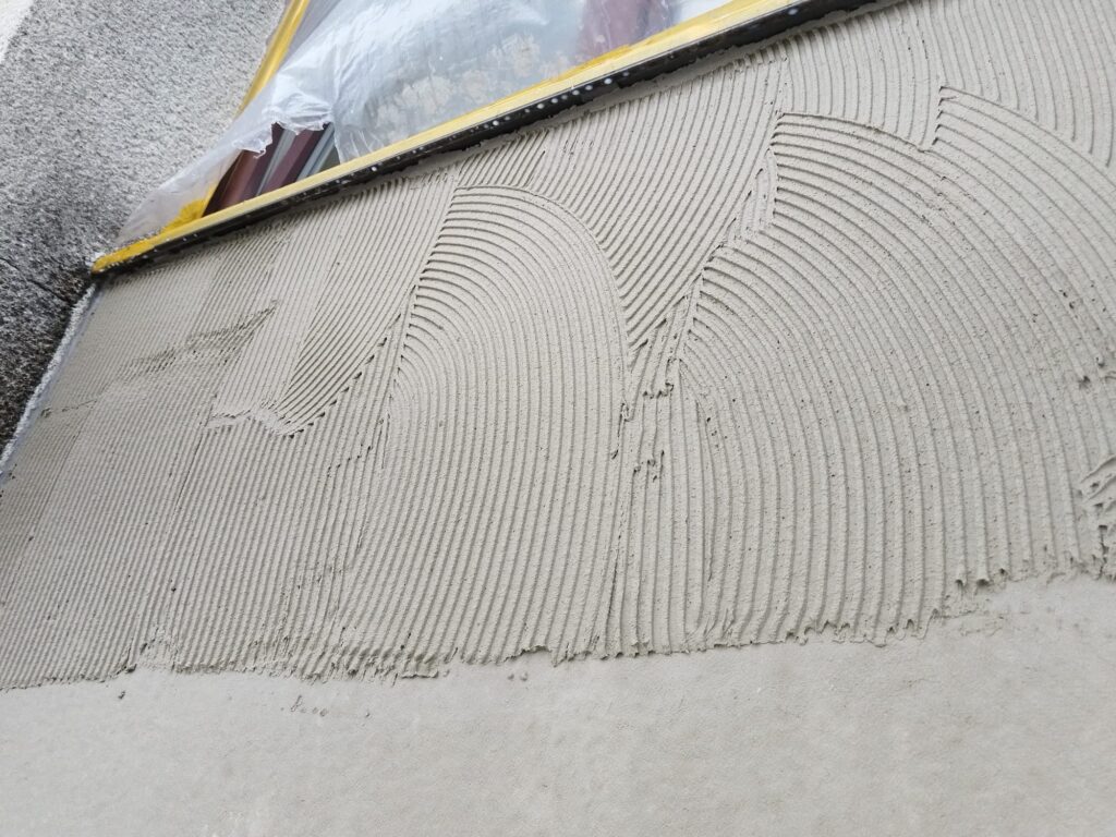 Aufgetragener Klebespachtel auf der Fassadenfläche