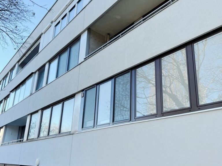 Sanierte Putzfassade mit neuen Fenstern eines Wohnhauses
