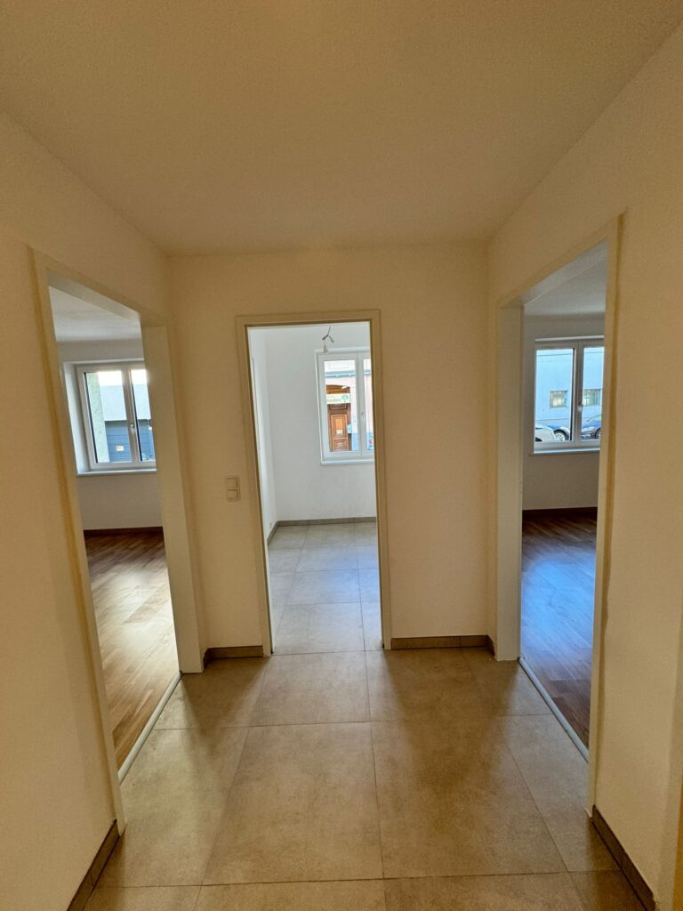 Flur mit Fliesenboden und Zimmertüren nach der Sanierung